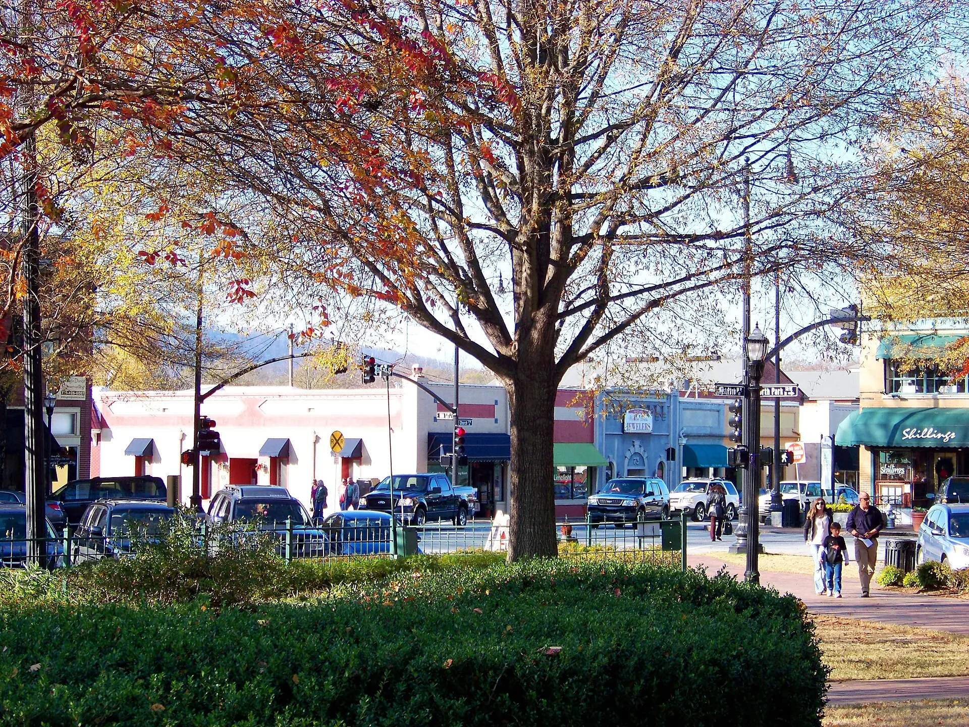 Marietta Square. Painted shopfronts on Marietta Square behind a tree in autumn color